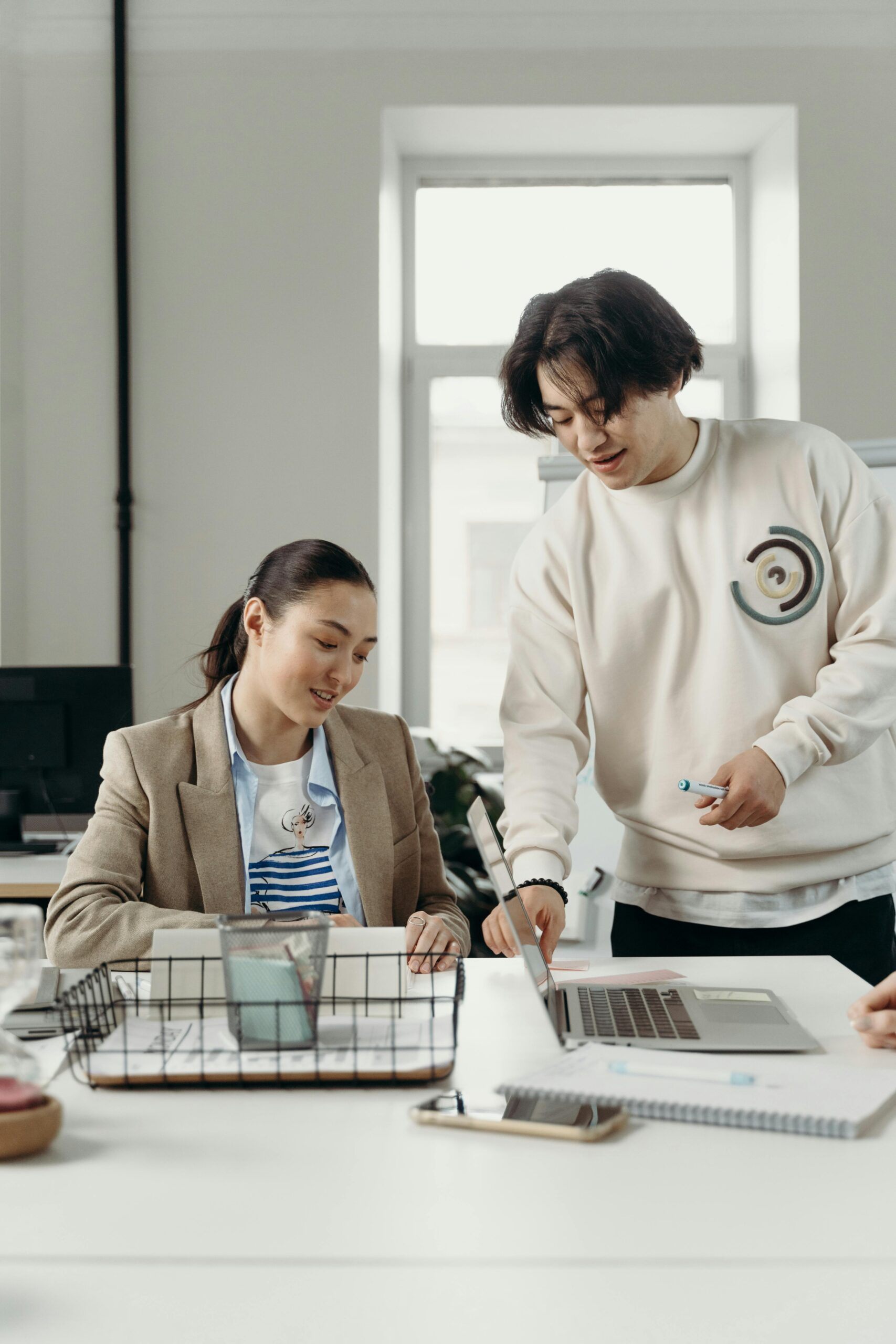 Diverse professionals engage in teamwork and project planning in a bright modern office setting.